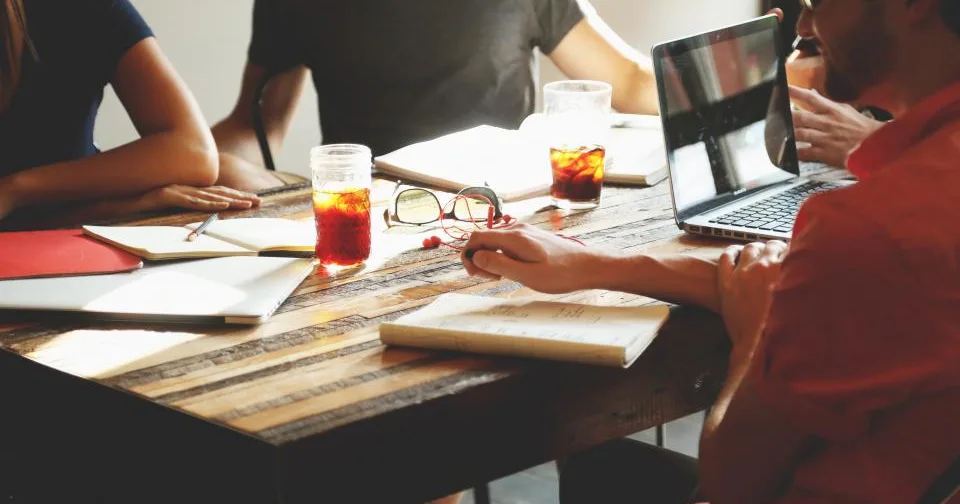 A team meeting around a table in an agency office